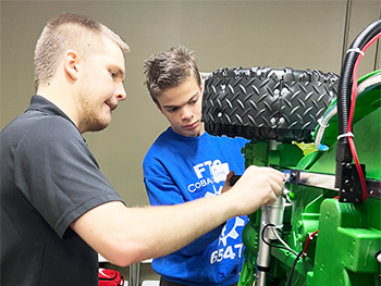 Two volunteers working on a car