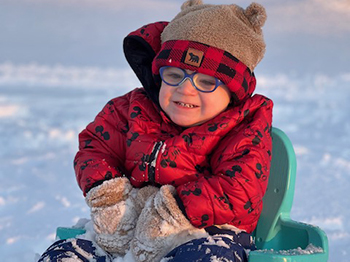 Chandler on a sled in the snow