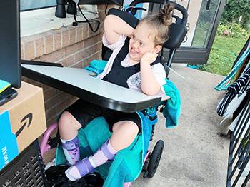 Juniper in her car on delivery day with her family and volunteers